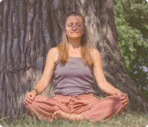 Woman meditating with closed eyes under tree